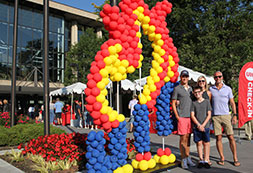 Photo of family posing by UIC balloons. Links to Gifts That Pay You Income