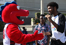 Photo of UIC mascot shaking hands with a student. Links to Gifts of Real Estate